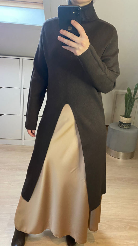 Sweaterjurk met coltrui hals en een spleet aan de voorkant. Kleur Donker Bruin. Totale lengte: 106 cm.